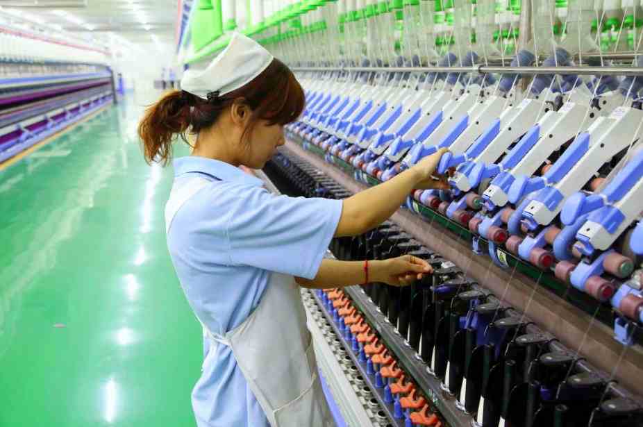Workers in the spinning workshop are spinning yarn